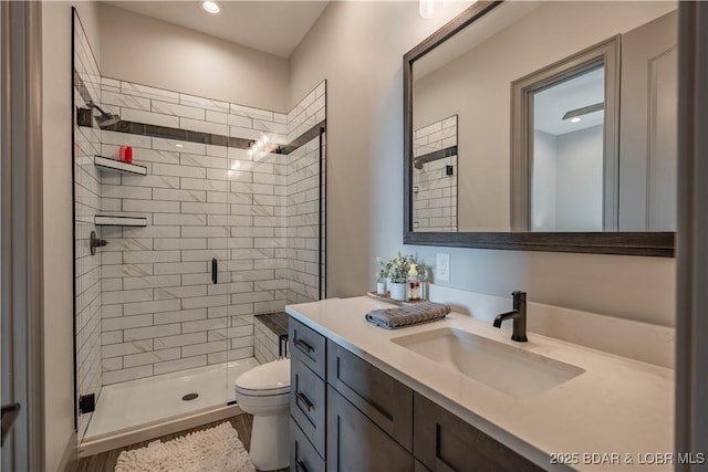 bathroom featuring vanity, an enclosed shower, and toilet