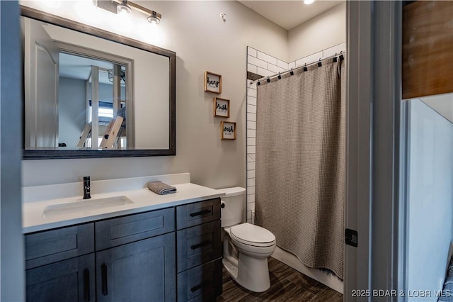 bathroom with a shower with curtain, hardwood / wood-style floors, vanity, and toilet