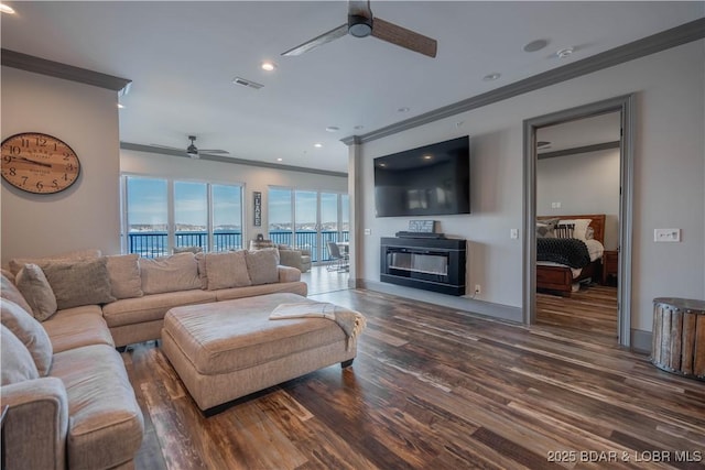 living room featuring a fireplace, ceiling fan, dark hardwood / wood-style flooring, and ornamental molding