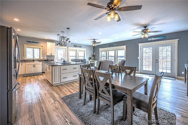 dining space featuring french doors, sink, and light hardwood / wood-style floors