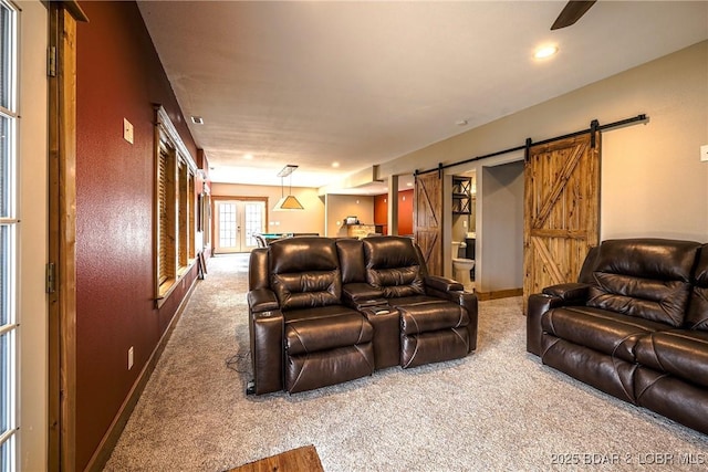 home theater room with a barn door and carpet floors