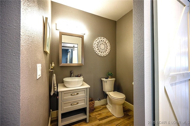 bathroom with vanity, hardwood / wood-style floors, and toilet