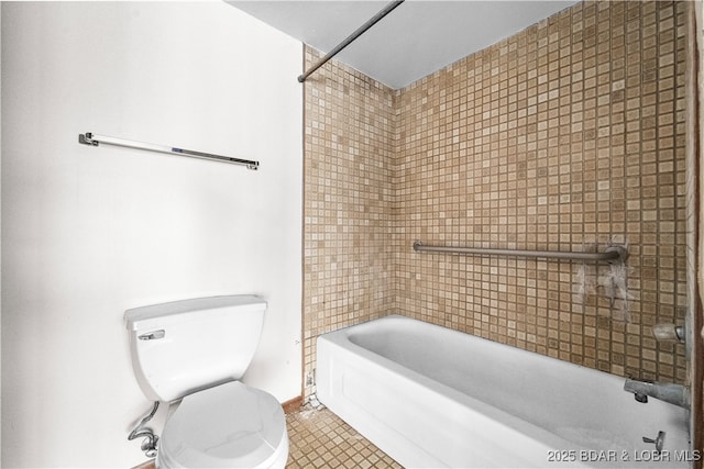 bathroom with tile patterned floors, tiled shower / bath combo, and toilet