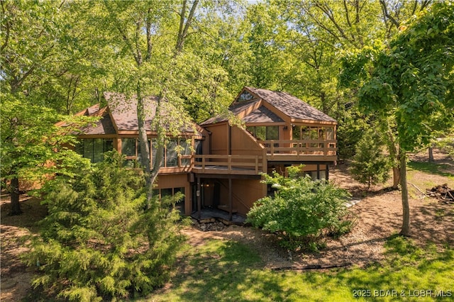 rear view of house featuring a wooden deck