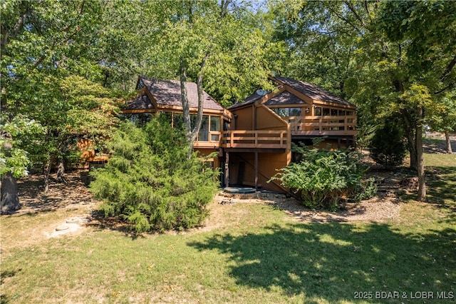 rear view of property featuring a yard and a deck