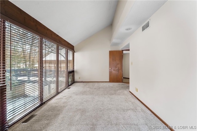 empty room with light colored carpet and lofted ceiling