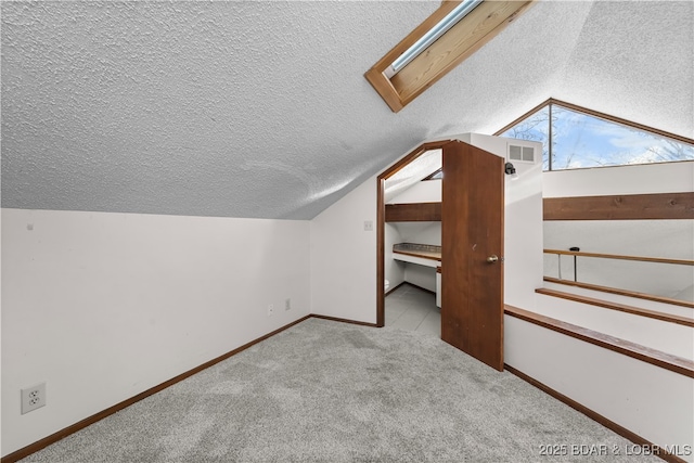 bonus room with lofted ceiling with skylight and light carpet