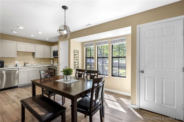 dining area featuring sink and light hardwood / wood-style floors