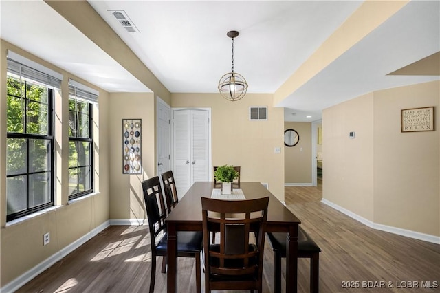 dining space featuring a notable chandelier and dark hardwood / wood-style floors