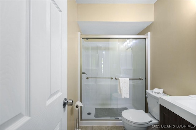 bathroom featuring tile patterned flooring, vanity, toilet, and an enclosed shower