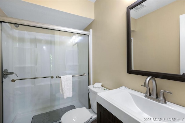 bathroom with vanity, an enclosed shower, and toilet