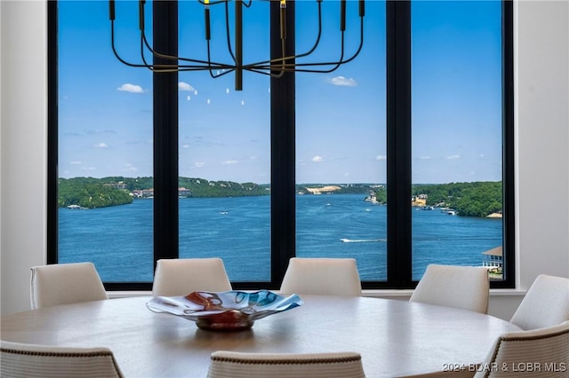 dining room with a water view and a chandelier