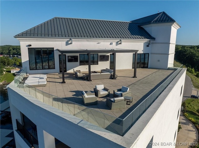 back of property featuring an outdoor living space with a fireplace and a patio