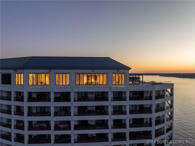 back house at dusk featuring a water view