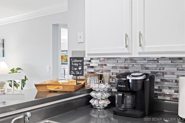 details with tasteful backsplash, white cabinetry, and crown molding