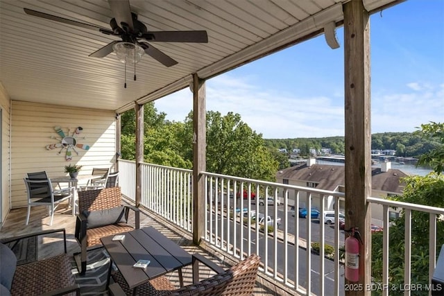 deck featuring ceiling fan and a water view