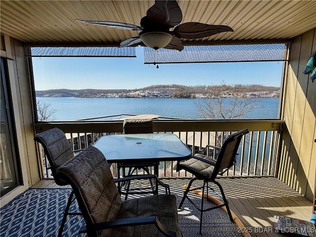 wooden terrace with a water view and ceiling fan