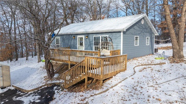 snow covered house with a deck