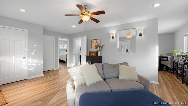 living room with ceiling fan and light hardwood / wood-style floors