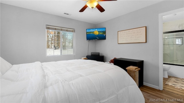 bedroom featuring ensuite bath, ceiling fan, and hardwood / wood-style flooring