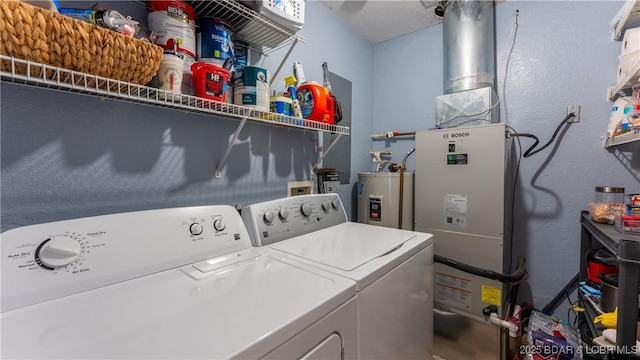 clothes washing area with washing machine and dryer and water heater