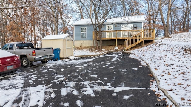 view of front of home with a storage unit and a deck