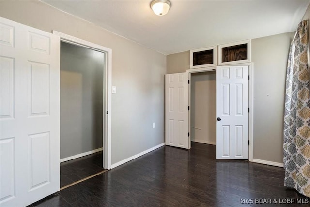 unfurnished bedroom with dark wood-type flooring and a closet