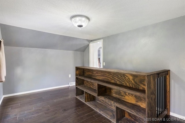 bonus room with a textured ceiling and vaulted ceiling