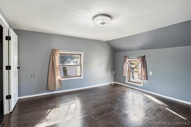 bonus room featuring lofted ceiling, dark wood-type flooring, and a textured ceiling