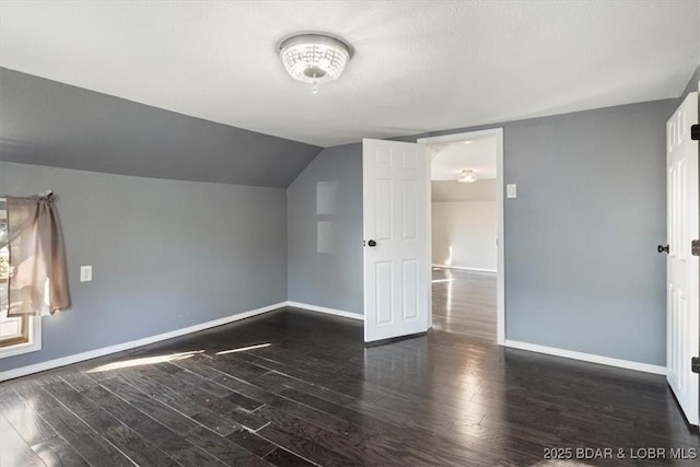 additional living space featuring lofted ceiling and dark hardwood / wood-style flooring