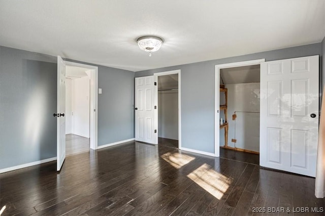 unfurnished bedroom with a closet and dark wood-type flooring