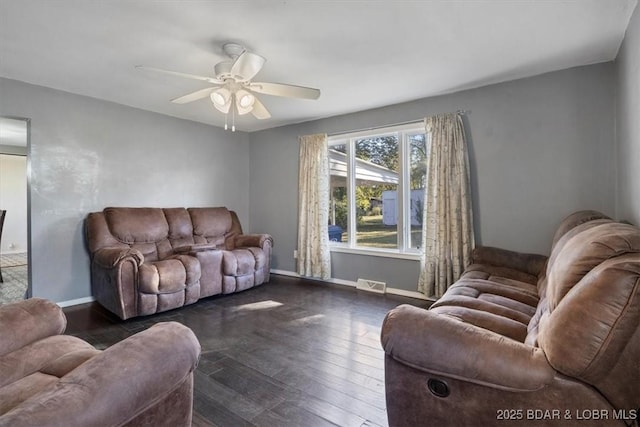 living room featuring dark wood-type flooring and ceiling fan