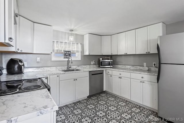 kitchen with light stone counters, decorative light fixtures, stainless steel appliances, white cabinets, and sink