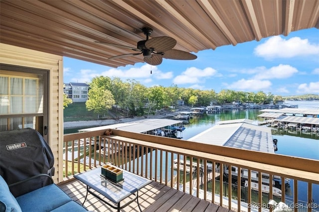 wooden deck with a grill, ceiling fan, and a water view