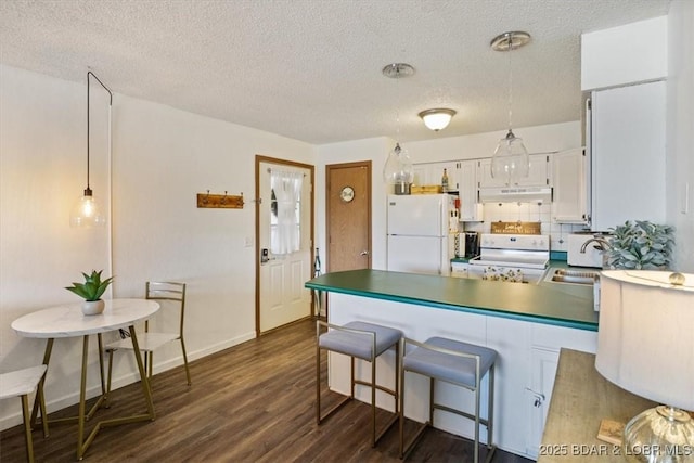 kitchen with white appliances, pendant lighting, backsplash, dark hardwood / wood-style flooring, and white cabinets