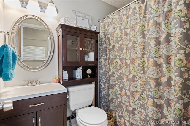 bathroom with toilet, a textured ceiling, and vanity