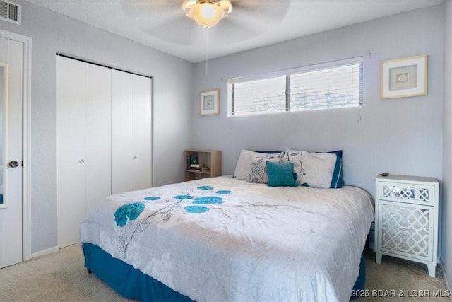 carpeted bedroom featuring ceiling fan and a closet