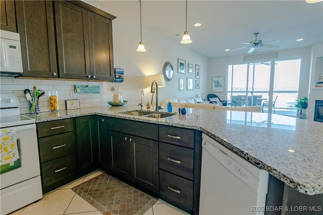 kitchen featuring kitchen peninsula, sink, white appliances, and light tile patterned flooring