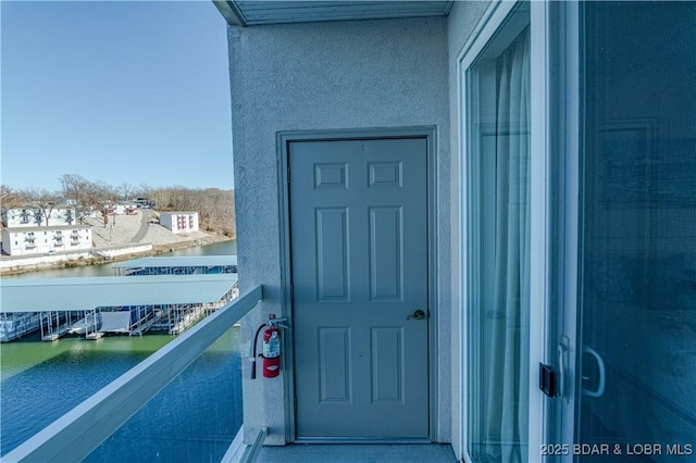 entrance to property featuring a water view and a balcony