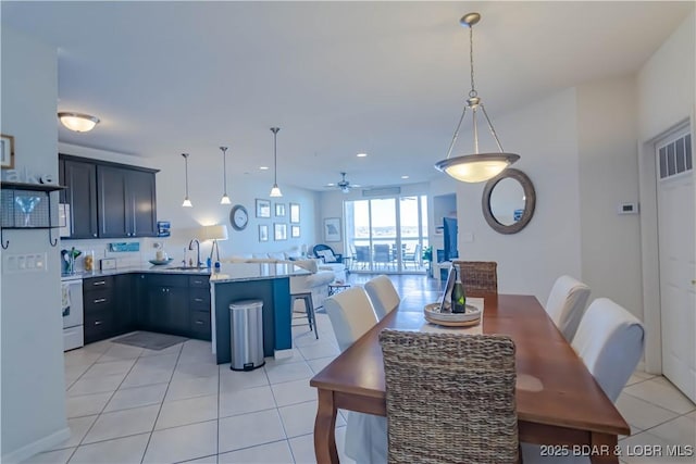 dining space with ceiling fan, light tile patterned floors, and sink