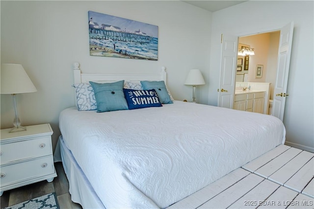 bedroom with hardwood / wood-style floors and ensuite bath