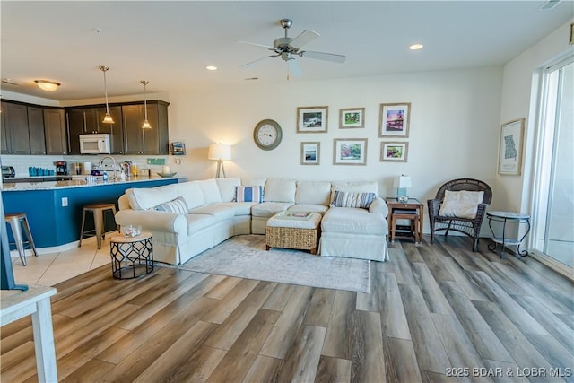 living room featuring ceiling fan and light wood-type flooring