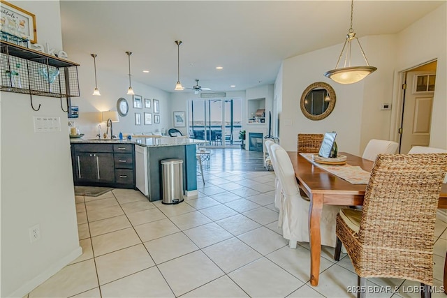 kitchen featuring ceiling fan, sink, light tile patterned flooring, and pendant lighting