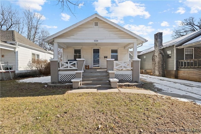 bungalow-style house with covered porch and a front lawn