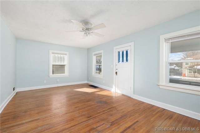 unfurnished room featuring ceiling fan, a wealth of natural light, and hardwood / wood-style flooring