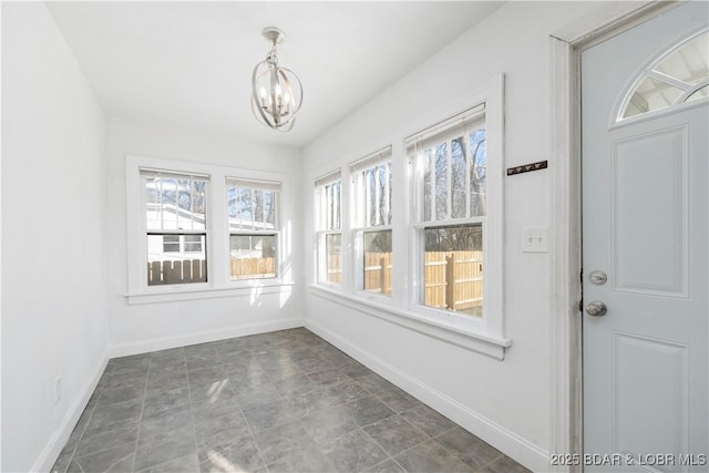 unfurnished sunroom with an inviting chandelier and plenty of natural light