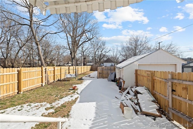 yard covered in snow featuring a garage and an outdoor structure