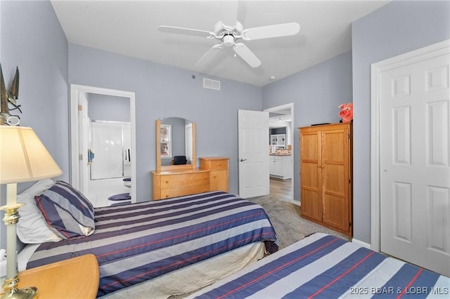 bedroom featuring ensuite bathroom, carpet flooring, and ceiling fan