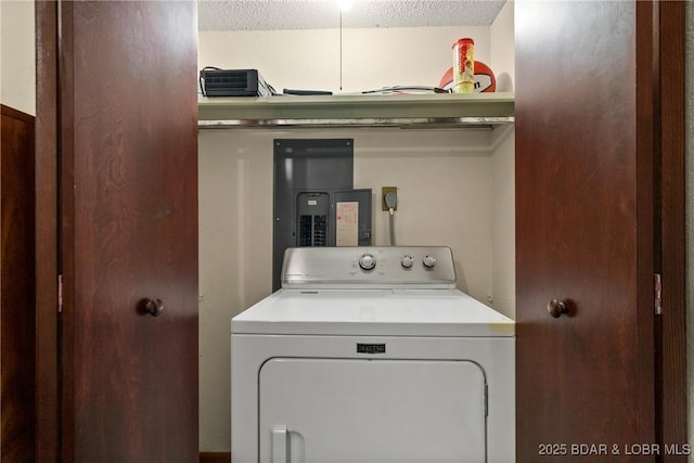 clothes washing area with washer / dryer, a textured ceiling, and wood walls