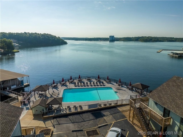 view of pool with a water view and a patio area